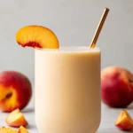 Amazing Peach Smoothie Recipes for Quick Mornings 9 Refreshing peach smoothie with fresh peach slices, ideal for inspiring new peach smoothie recipes.
