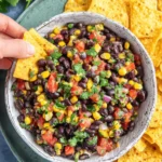 Amazing Black Bean and Corn Salsa Recipe 8 Vibrant black bean and corn salsa in a rustic bowl, ready to be scooped with golden tortilla chips.