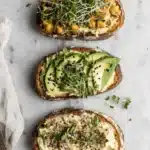The Ultimate Hummus Toast Guide: Quick & Easy 5 Three vibrant variations of hummus toast on artisan bread, garnished with chickpeas, avocado, and Everything Bagel seasoning.