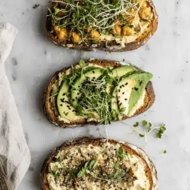 The Ultimate Hummus Toast Guide: Quick & Easy 4 Three vibrant variations of hummus toast on artisan bread, garnished with chickpeas, avocado, and Everything Bagel seasoning.