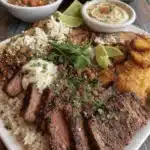 Ultimate Steak Cheese and Rice: Easy Dinner 5 Close-up of a vibrant Mexican-inspired platter featuring perfectly grilled steak, fluffy white rice, and flavorful Mexican rice, accompanied by plantains and pico de gallo, making for a delicious Steak Cheese and Rice style meal.