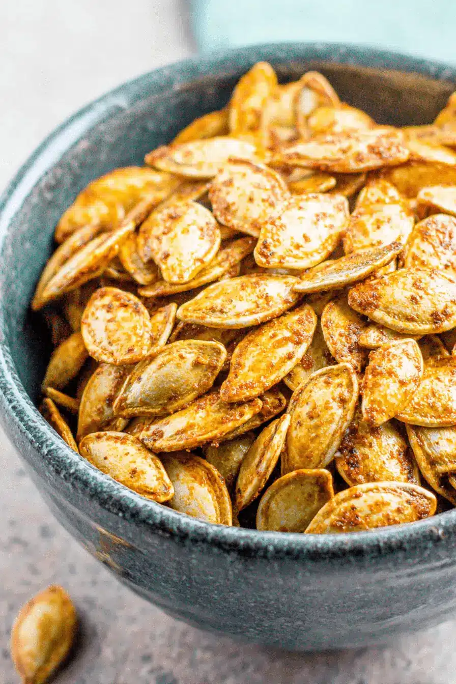 The Ultimate Pumpkin Seeds Recipe: Crunchy & Easy 2 Rustic ceramic bowl filled with golden-brown roasted pumpkin seeds, showcasing a delicious pumpkin seeds recipe.