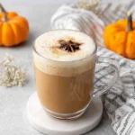 Amazing Homemade Pumpkin Chai Latte 6 Warm pumpkin chai latte in a clear mug with star anise, surrounded by autumn decor.