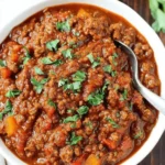 Amazing One-Pot Pumpkin Chili Recipe 5 Close-up of a hearty bowl of pumpkin chili garnished with fresh parsley.