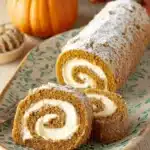 The Ultimate Foolproof Pumpkin Roll Recipe 6 Sliced pumpkin roll cake dusted with powdered sugar, ready to be enjoyed from this delicious pumpkin roll recipe.