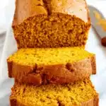 Amazing Foolproof Pumpkin Bread 7 Deliciously moist pumpkin bread, sliced and presented on a marble slab with autumnal decor.