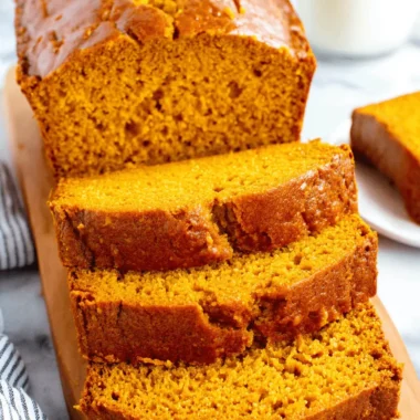 Unbelievably Moist Pumpkin Bread Recipe 3 Close-up of delicious, freshly baked pumpkin bread slices on a wooden cutting board.