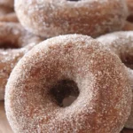 The Ultimate Baked Apple Cider Donuts Recipe 4 Close-up of golden-brown cinnamon sugar apple cider donuts, sparkling with sugar granules, a perfect treat from this apple cider donuts recipe.