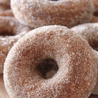 The Ultimate Baked Apple Cider Donuts Recipe 4 Close-up of golden-brown cinnamon sugar apple cider donuts, sparkling with sugar granules, a perfect treat from this apple cider donuts recipe.