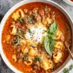 Sensational Lasagna Soup: Easy Weeknight Comfort 6 Close-up of a hearty bowl of Lasagna Soup, garnished with creamy ricotta, ground meat, and fresh basil.