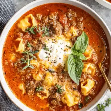 Sensational Lasagna Soup: Easy Weeknight Comfort 4 Close-up of a hearty bowl of Lasagna Soup, garnished with creamy ricotta, ground meat, and fresh basil.
